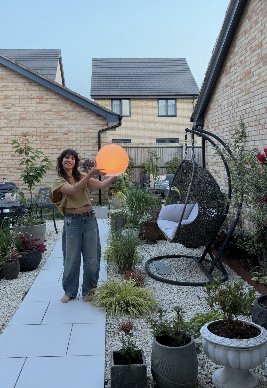 Mariné holding a plant in her home