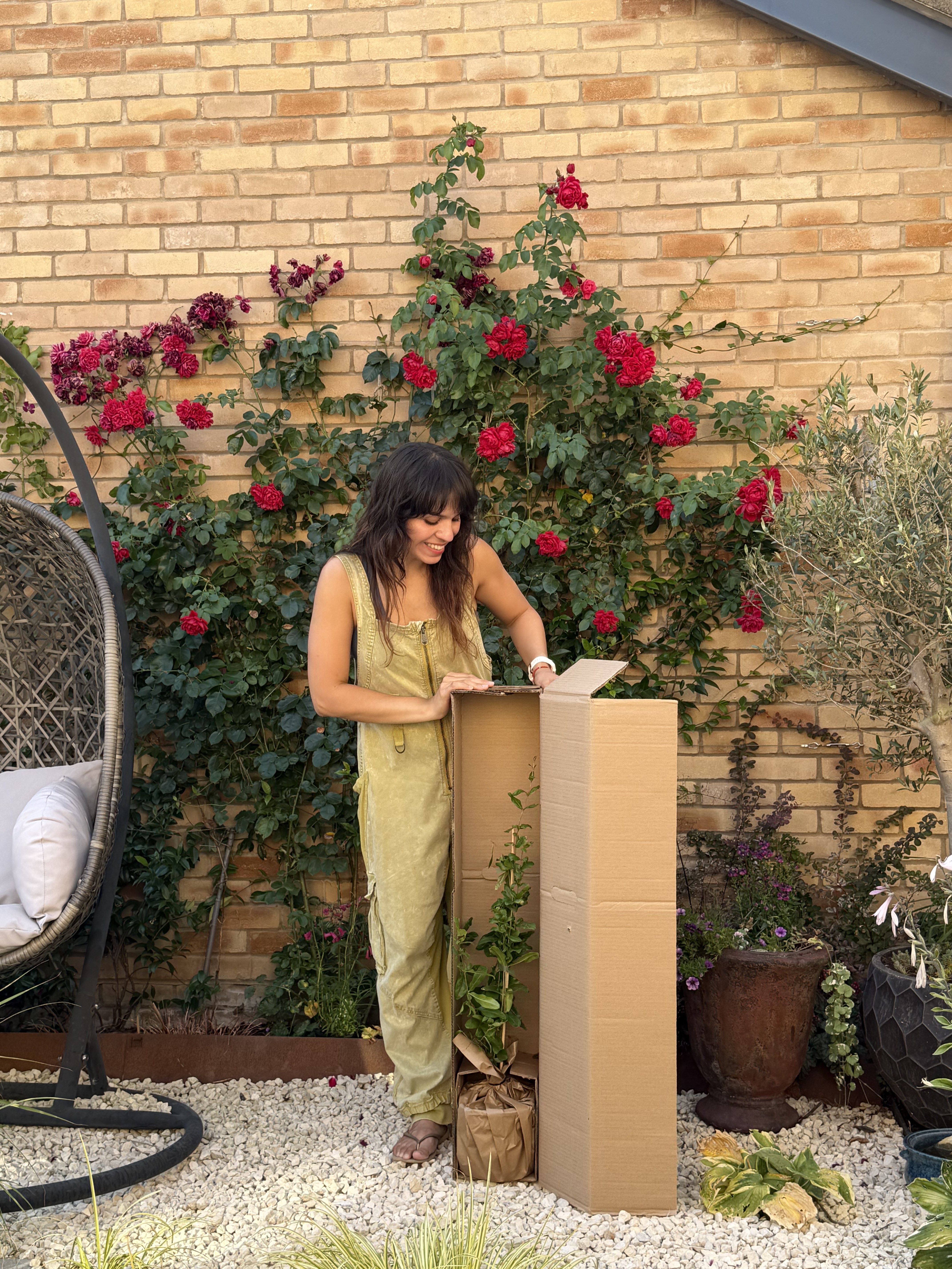 Mariné unboxing a delivery in her garden surrounded by roses